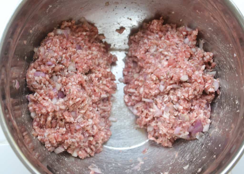 sausage meat formed into two portions in a bowl.