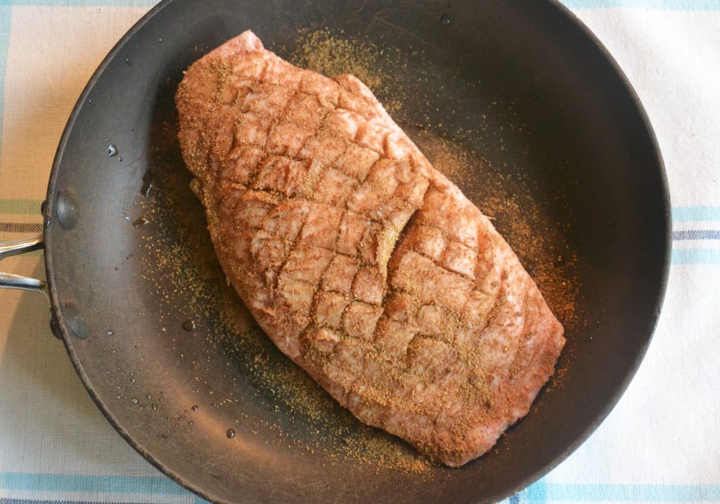 raw breast in a frying pan.
