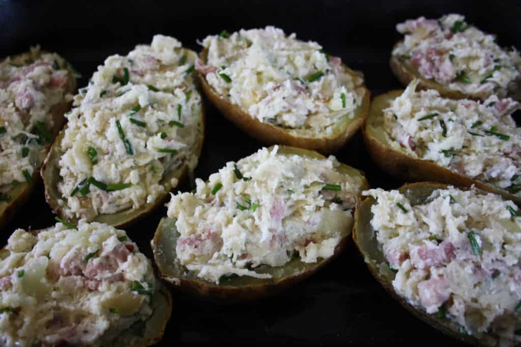 Twice Baked Stuffed Potatoes. Baked potato mixed with onions, bacon, cheese, garlic, chives and creme fraiche stuffed in potato skins and baked.