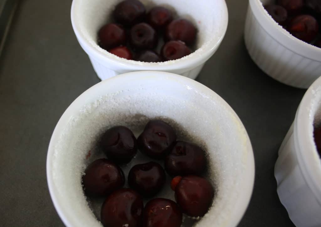cherries in the bottom of a ramekin dish.