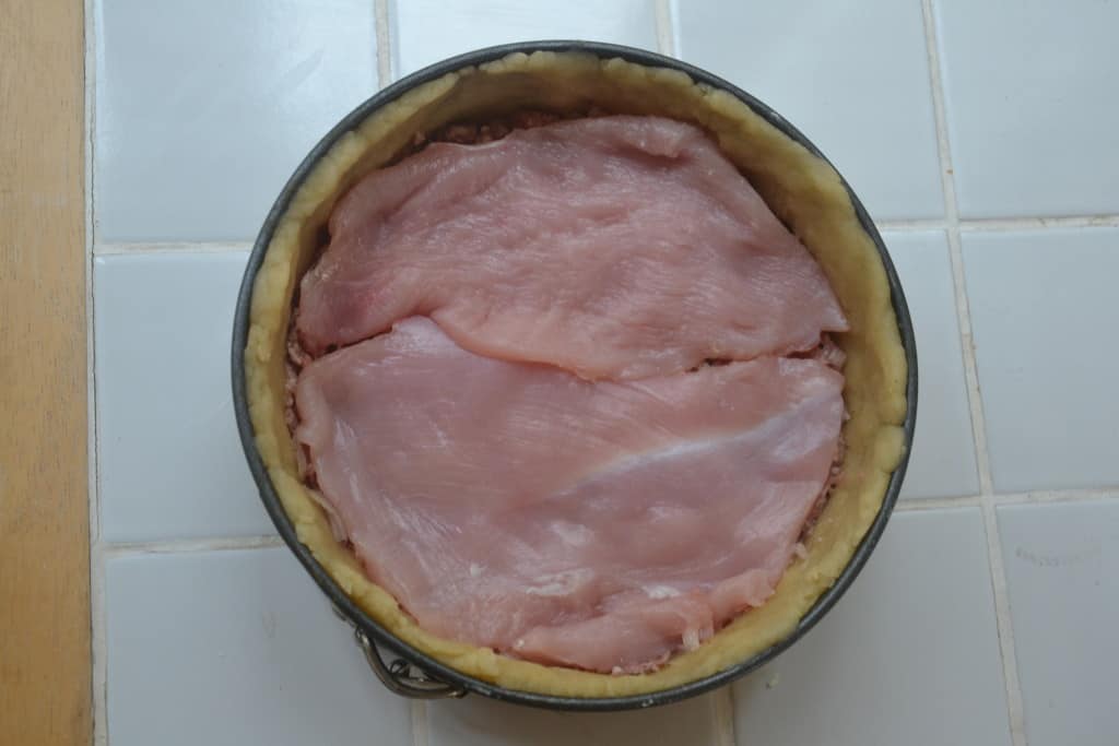 layer of turkey added to tin.