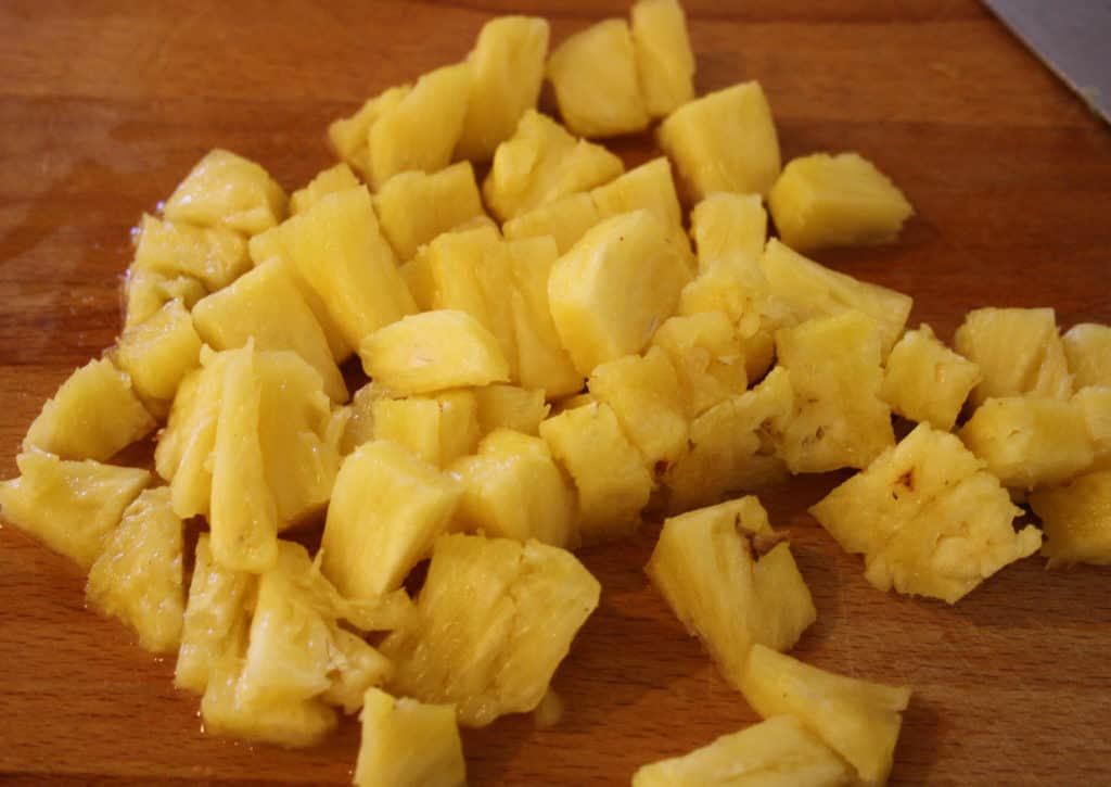 chopped fresh pinapple on a chopping board.