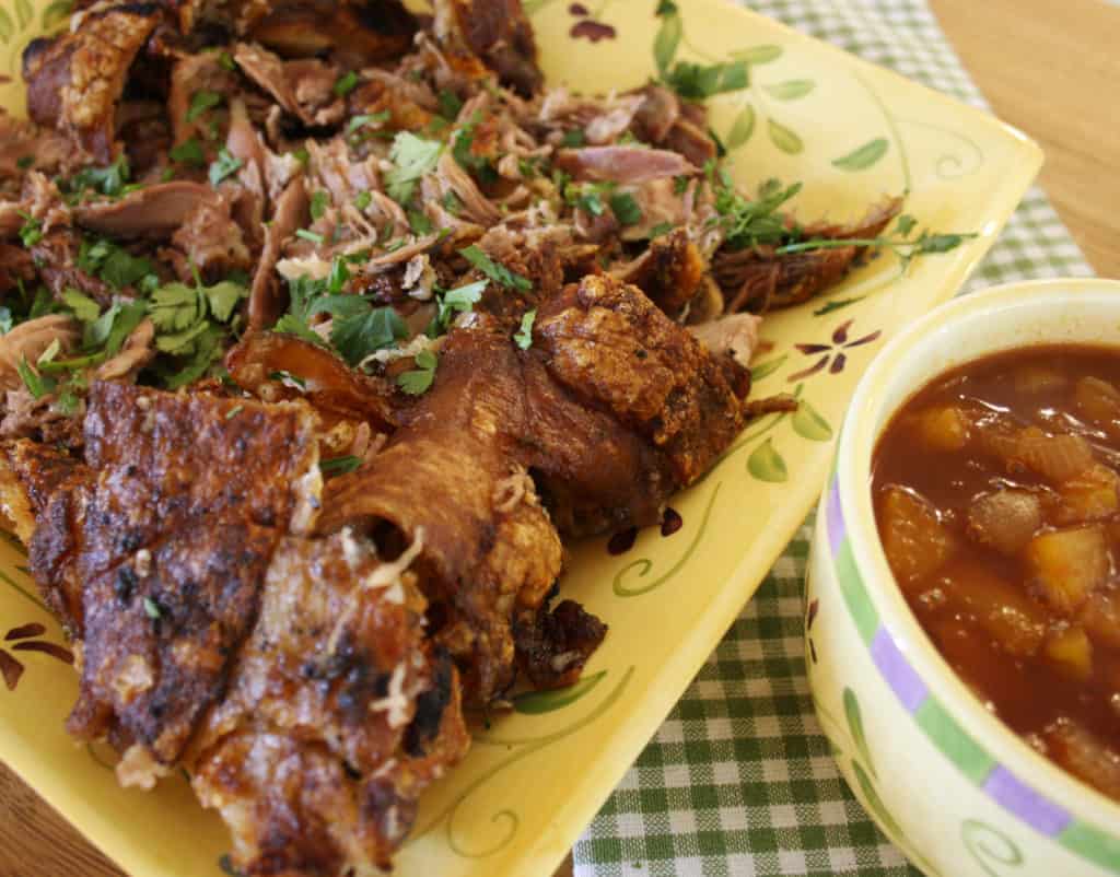 shredded pork meat on a place with pineapple sauce to the right side in a pot.