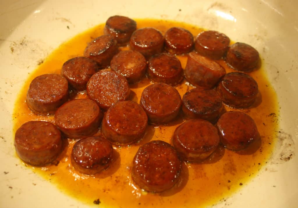 slices of chorizo frying in a pan