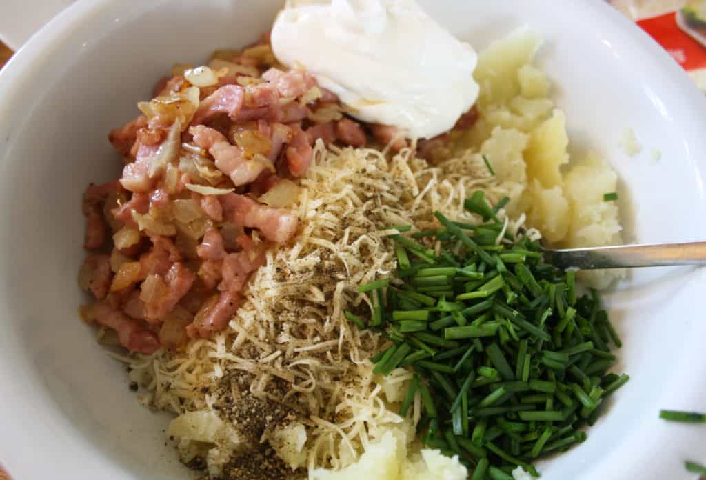 filling in a bowl including chives, bacon, cheese, creme fraiche.