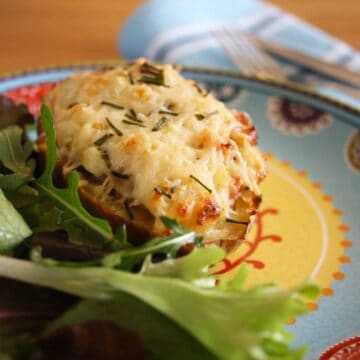 Twice Baked Stuffed Potatoes. Baked potato mixed with onions, bacon, cheese, garlic, chives and creme fraiche stuffed in potato skins and baked.