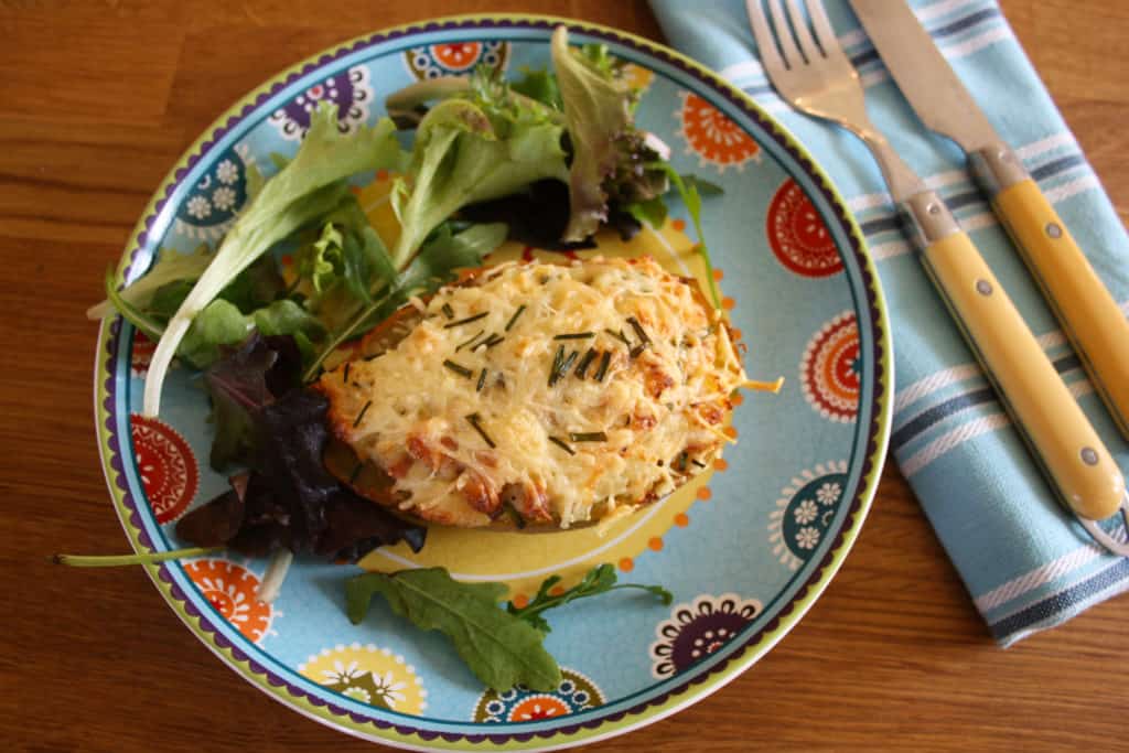 Twice Baked Stuffed Potatoes on a plate with salad.