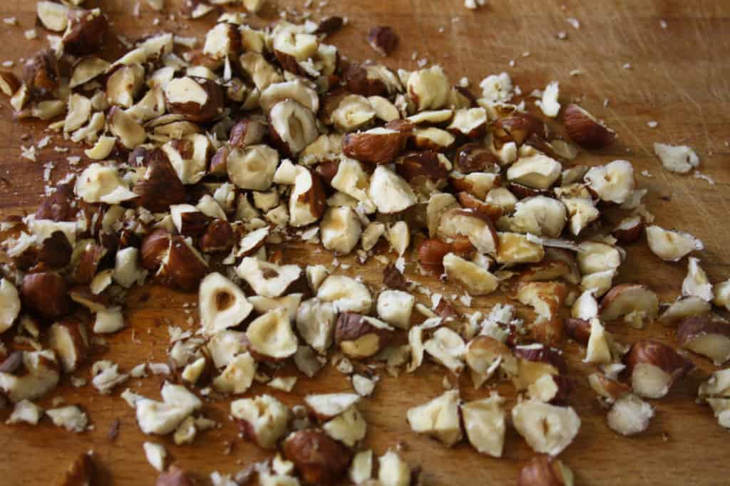 roughly chopped hazelnuts on a board.