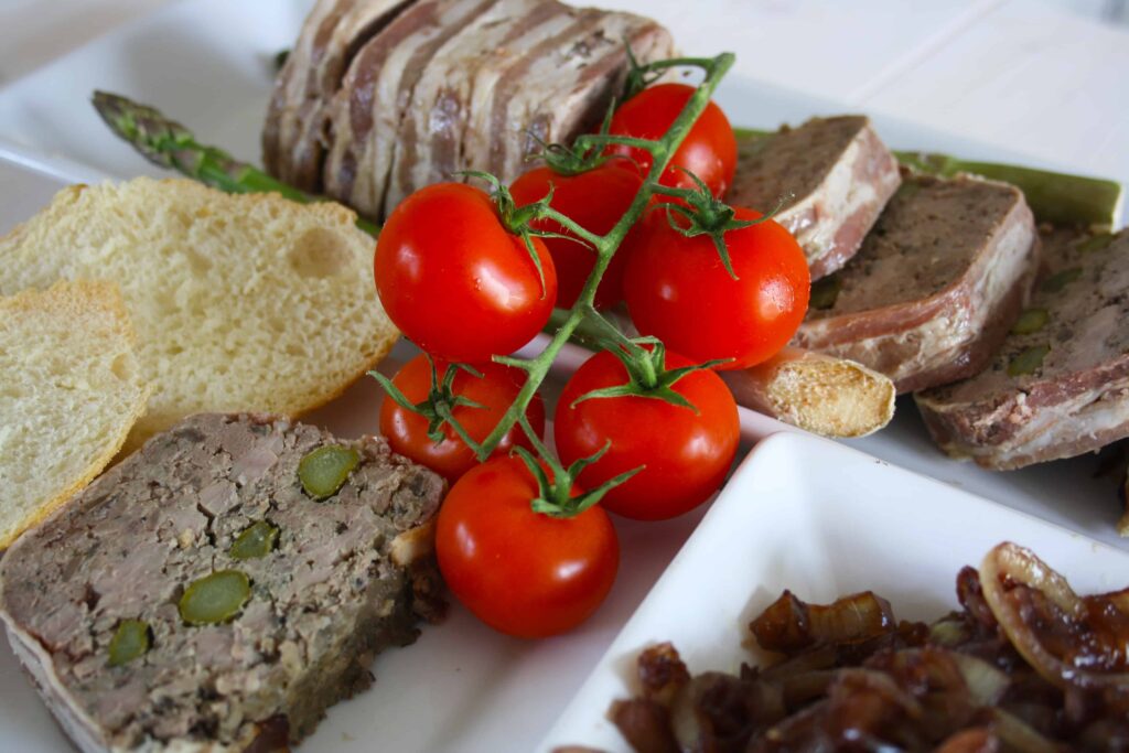 Duck Terrine with Asparagus. Layers of pork mince,liver, duck fillets and asparagus are all wrapped up in streaky bacon for a delicious starter.