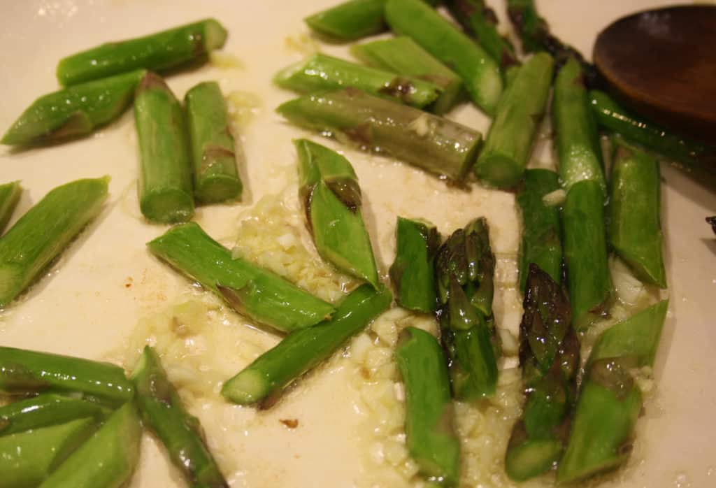 asparagus pieces in a pan with garlic.