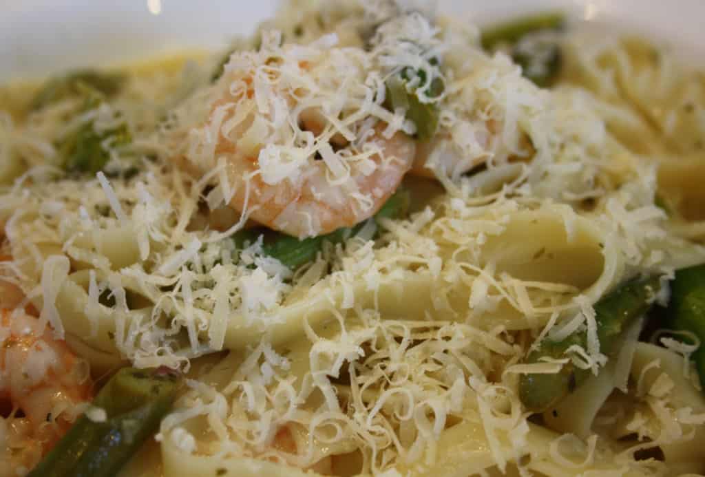 garlic prawn linguine pasta served on a plate with Parmesan on top.