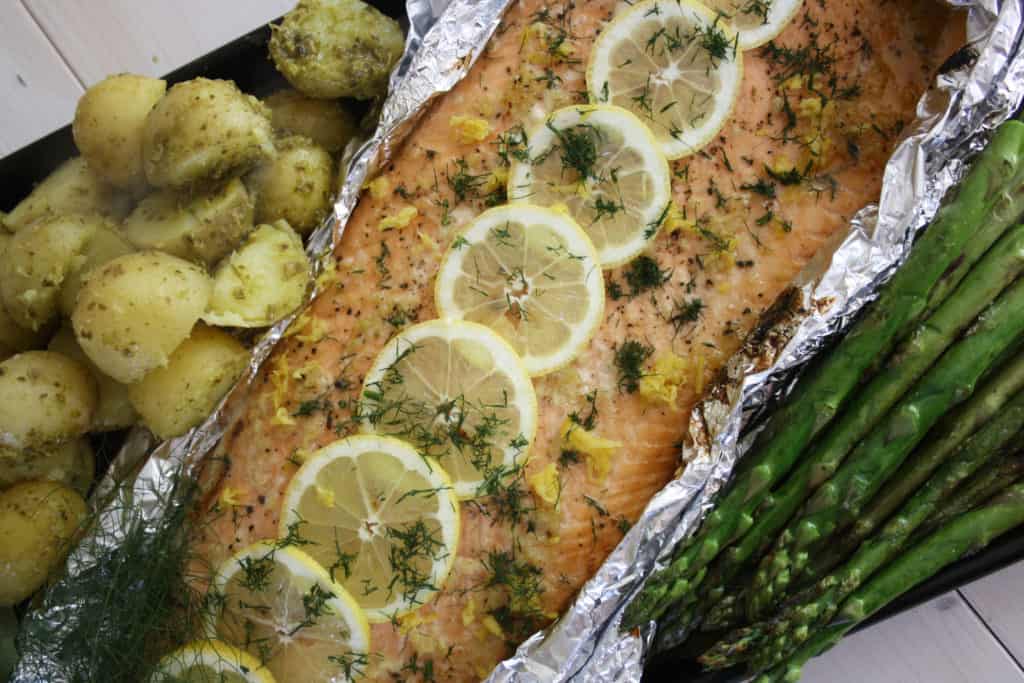 cooked salmon with some new potatoes and asparagus to each side