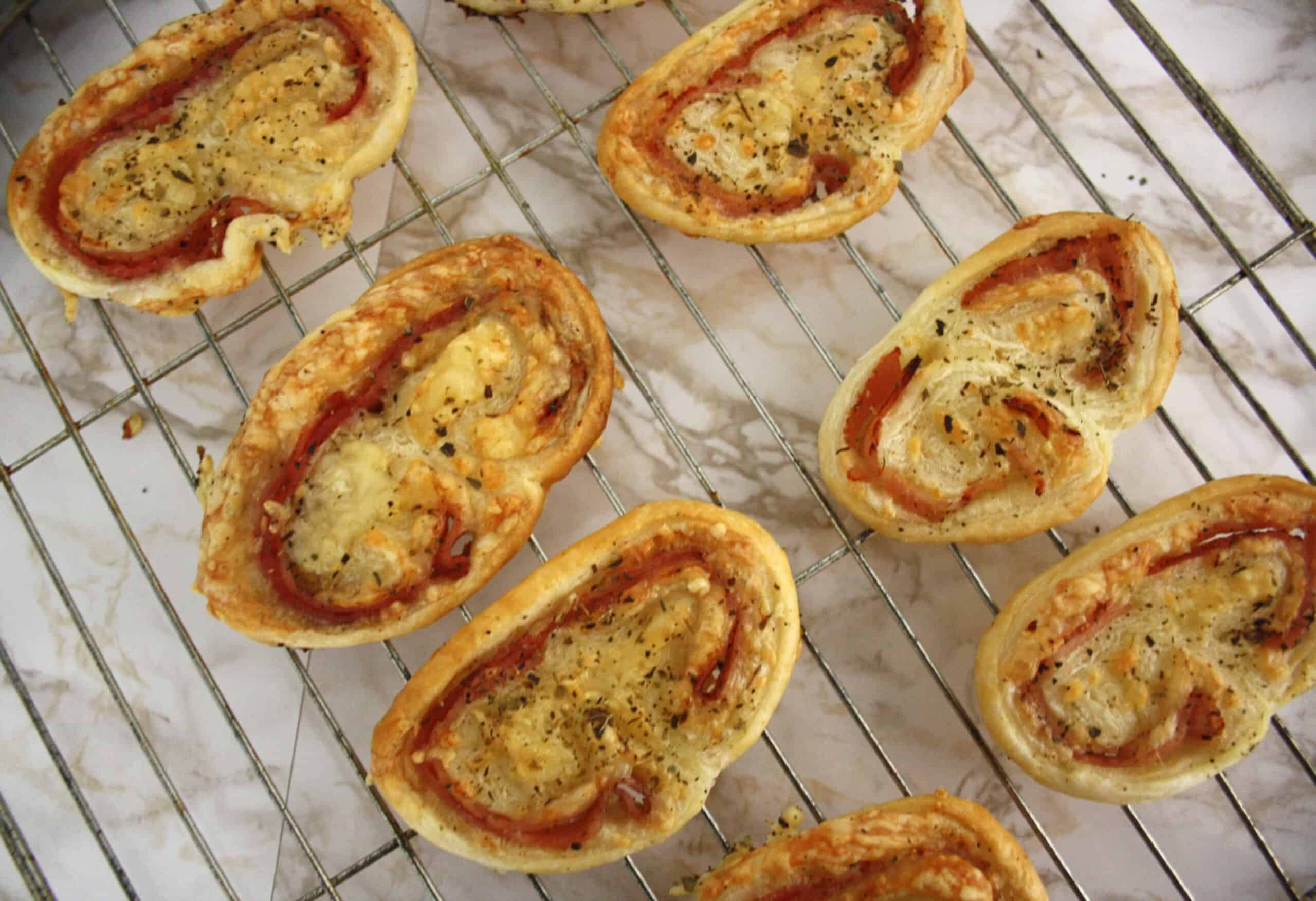 Ham and cheese palmiers on a cooling rackisp French biscuits are simple to do and perfect to serve to guests with drinks.