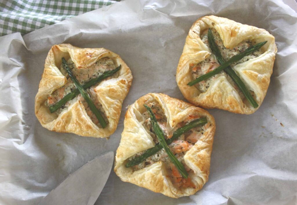 Salmon and Asparagus Puff Pastry Parcels. Poached salmon is mixed with Ricotta cheese, enveloped in puff pastry spread with basil pesto then baked.