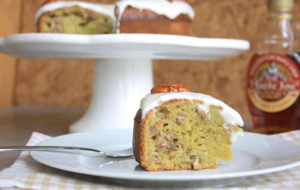 Slice ofPecan Banana Avocado Cake covered with icing.  