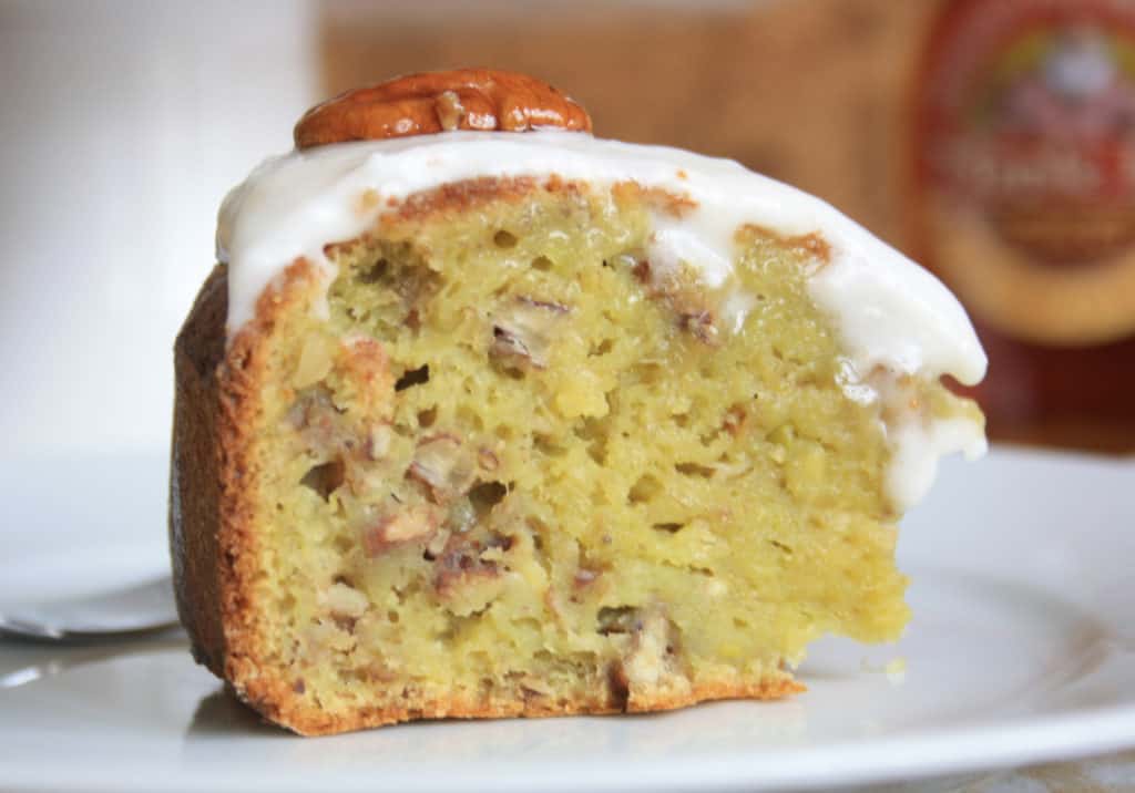 Slice ofPecan Banana Avocado Cake covered with icing. 