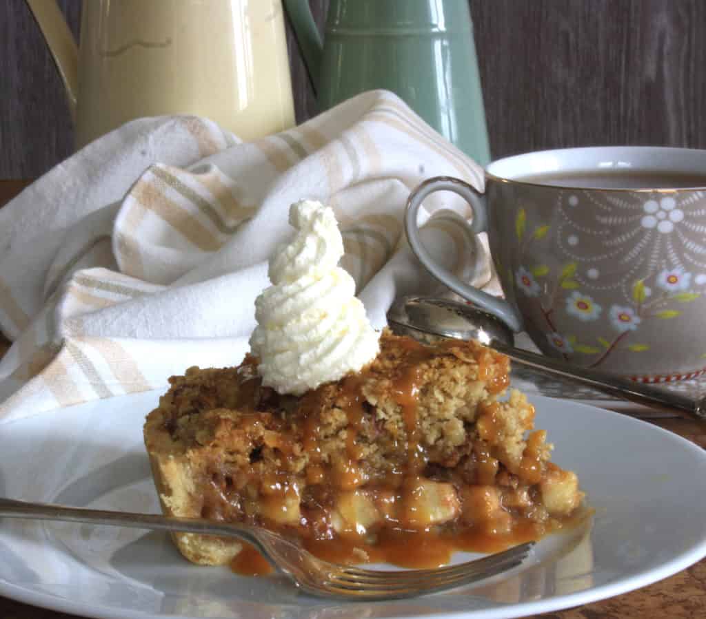 Apple  Tart slice with caramel pouring over the side.