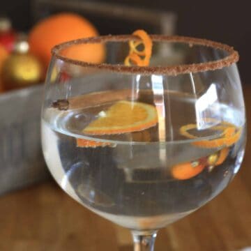 Gin-gle Bell Gin and Orange Liqueur Cocktail. Add a cinnamon and sugar crust to the glass, a few shreds of orange peel for a festive cocktail.