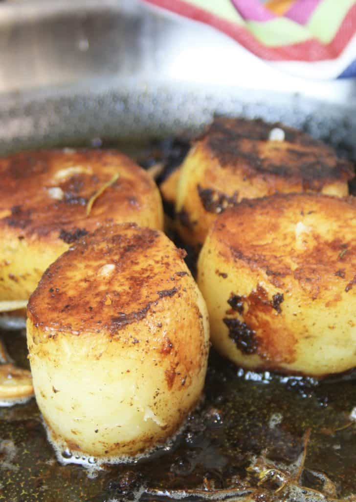 Side shot of potatoes cooking in a pan