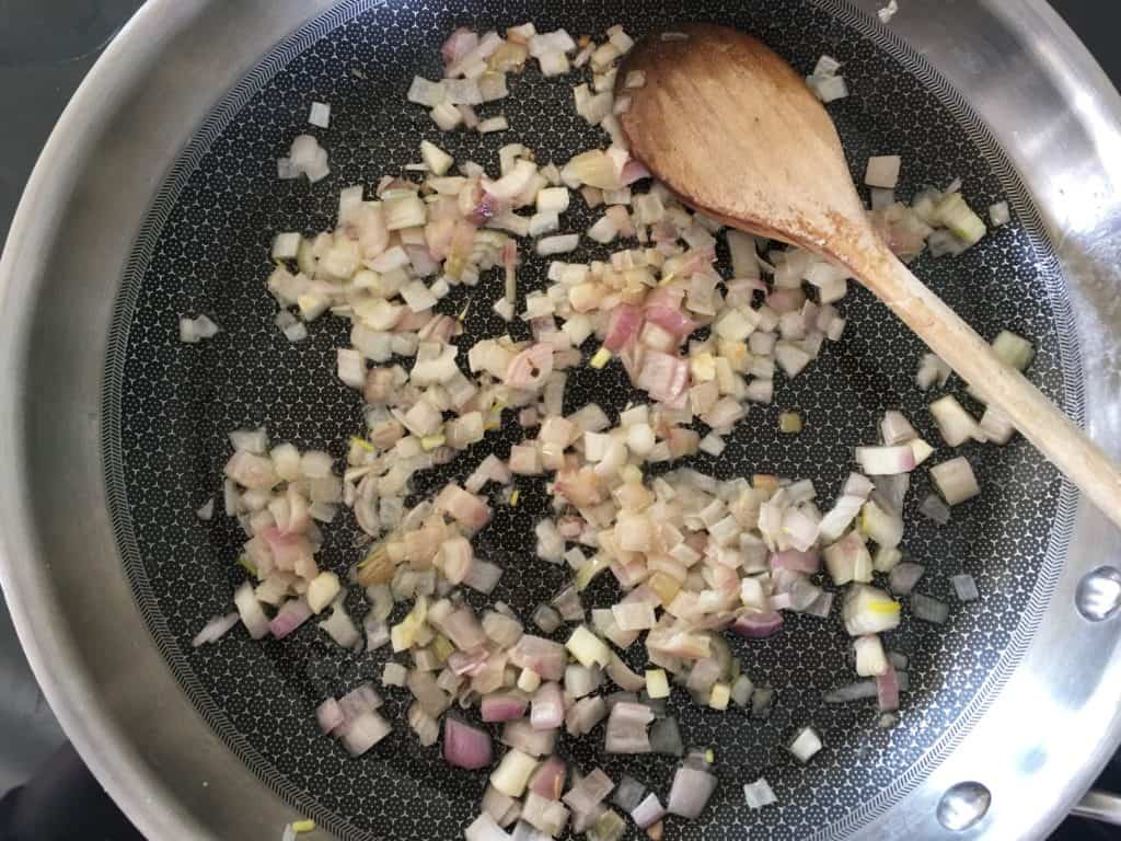 Pan with chopped shallots frying.