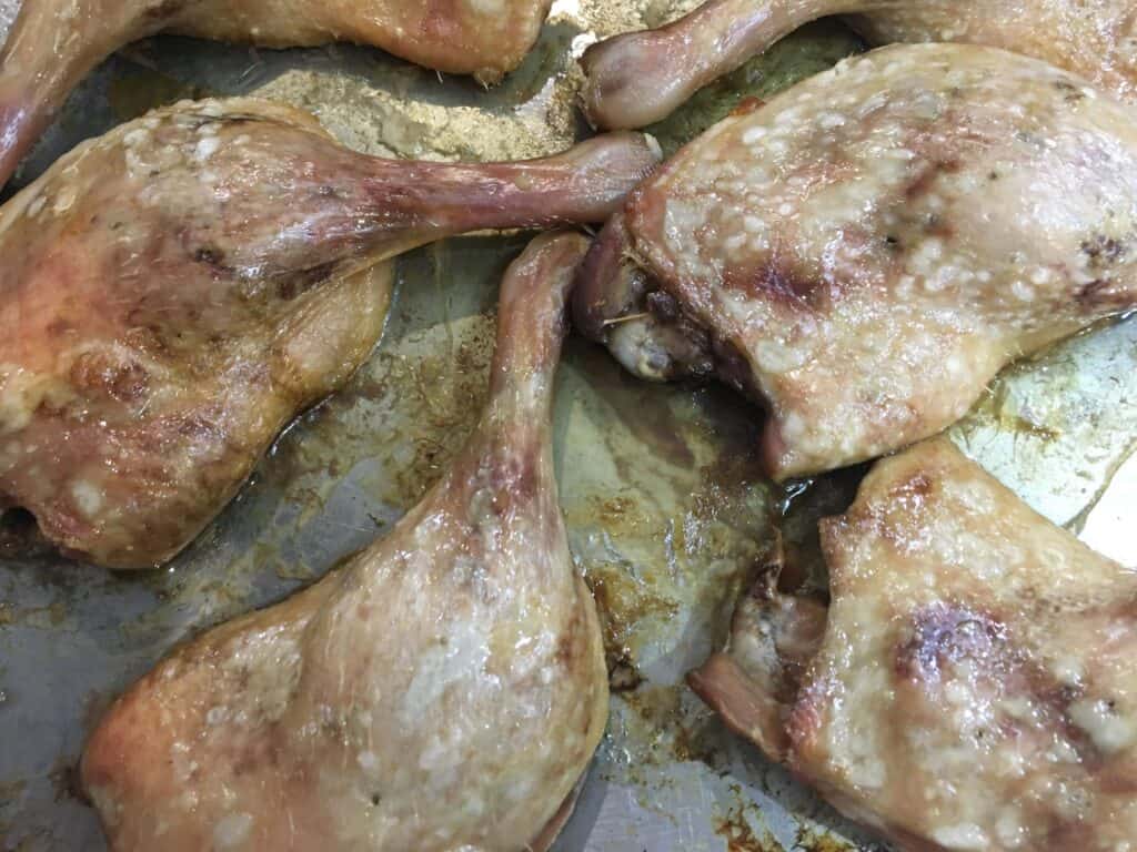 4 cooked duck legs in a pan