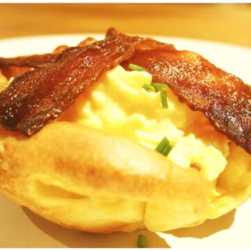 Yorkshire pudding filled with scrambled egg and topped with bacon