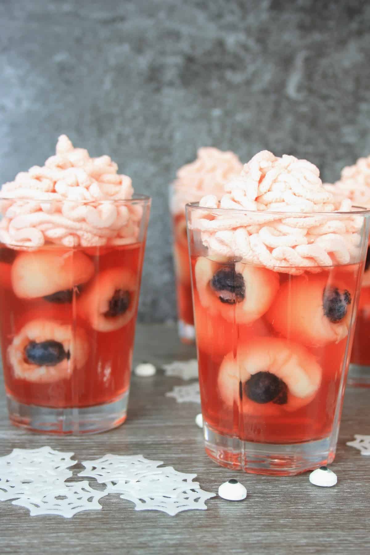 jelly eyeballs in a glass with pink whipped cream on top.