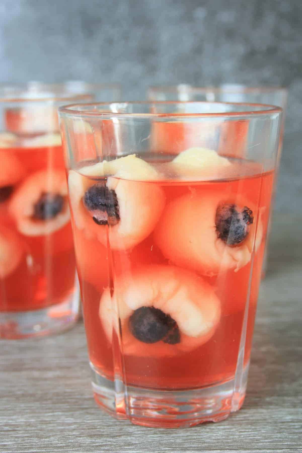 jelly and lychhes in a glass and another glass in the background