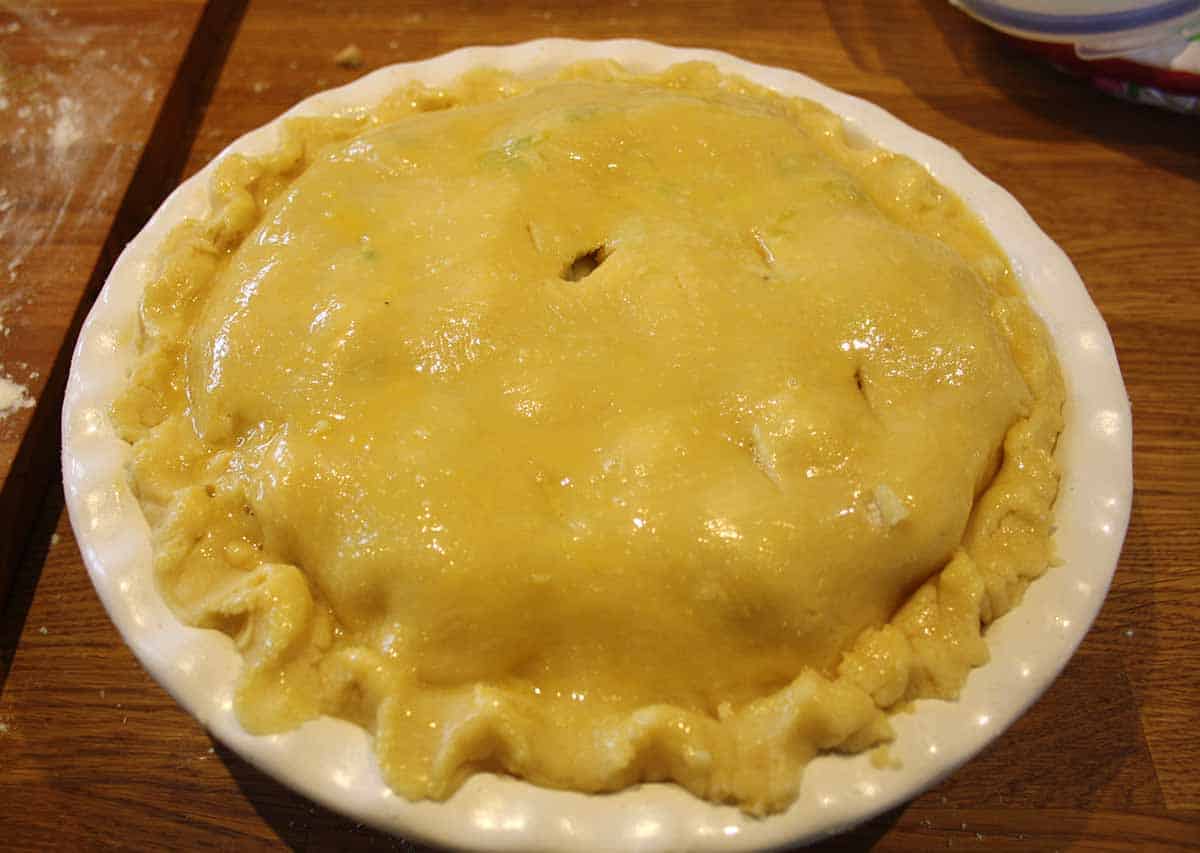 chicken and bacon pie with glazed top crust.