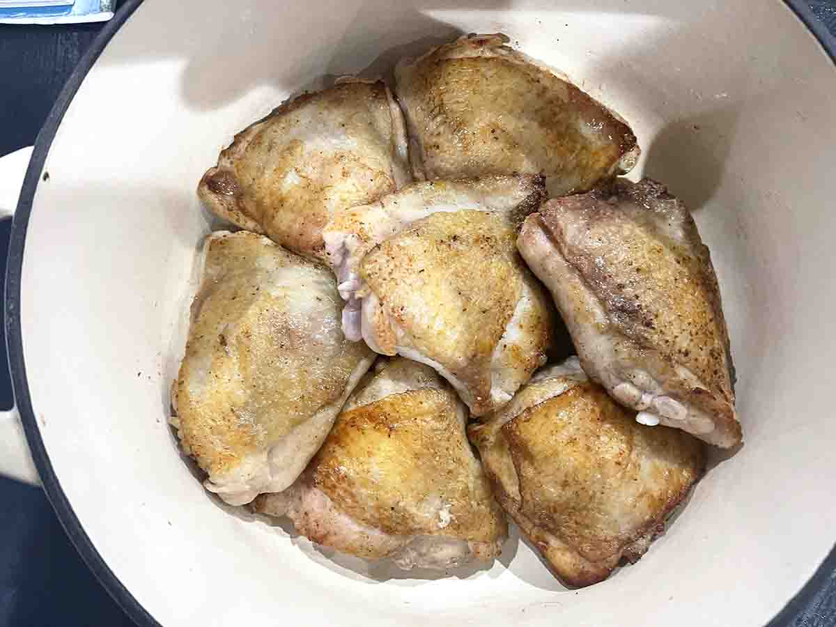 browned chicken thighs in a casserole dish.