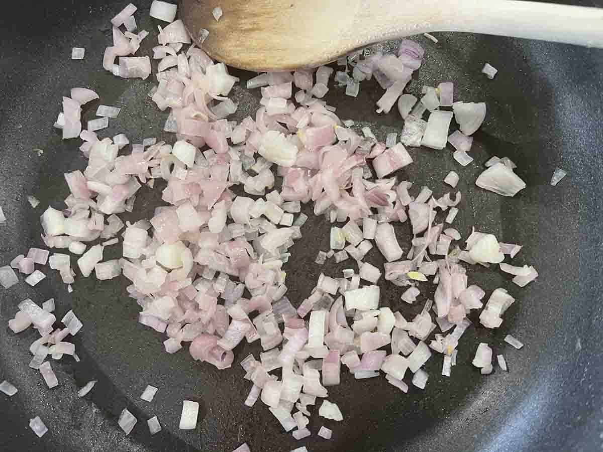 softened shallots in a frying pan.