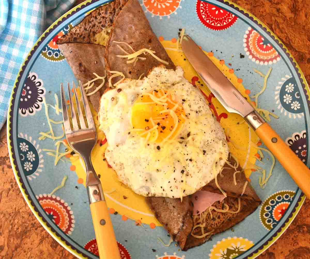 buckwheat galettes on a plate with an egg on top.