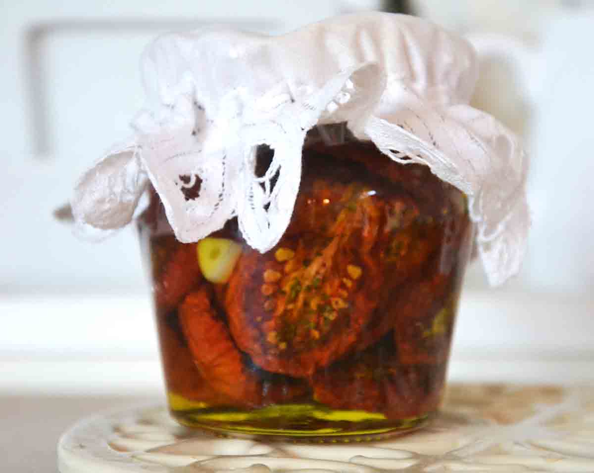 preserved tomatoes in oil in a jar with a lace cap.