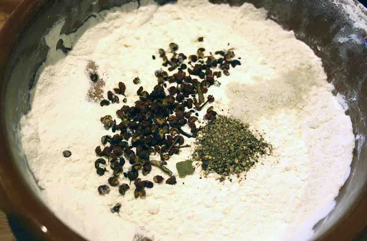 flour in a bowl with salt, pepper and szechuan.