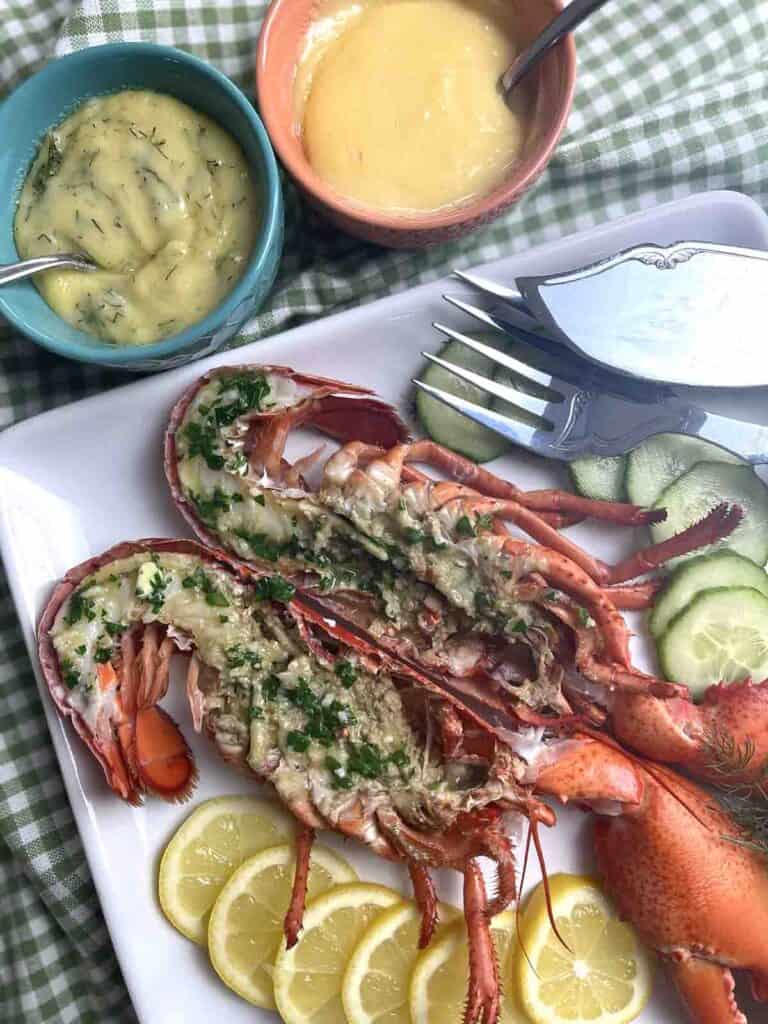 lobster on a plate with plain and dill mayonnaise in pots.