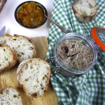 pot of pork rillettes with sliced bread, chutney and cucumber.
