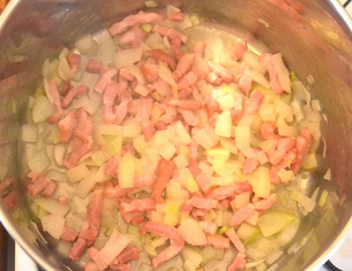 bacon and onion frying in a saucepan.