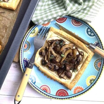 Vegetarian mushroom tart on a plate with cutlery.