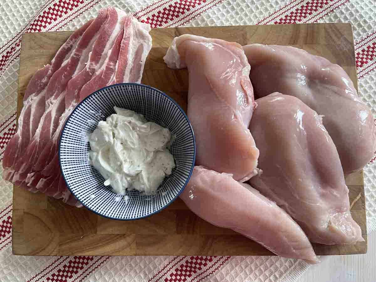 chicken breasts, streaky bacon and cream cheese in a bowl.
