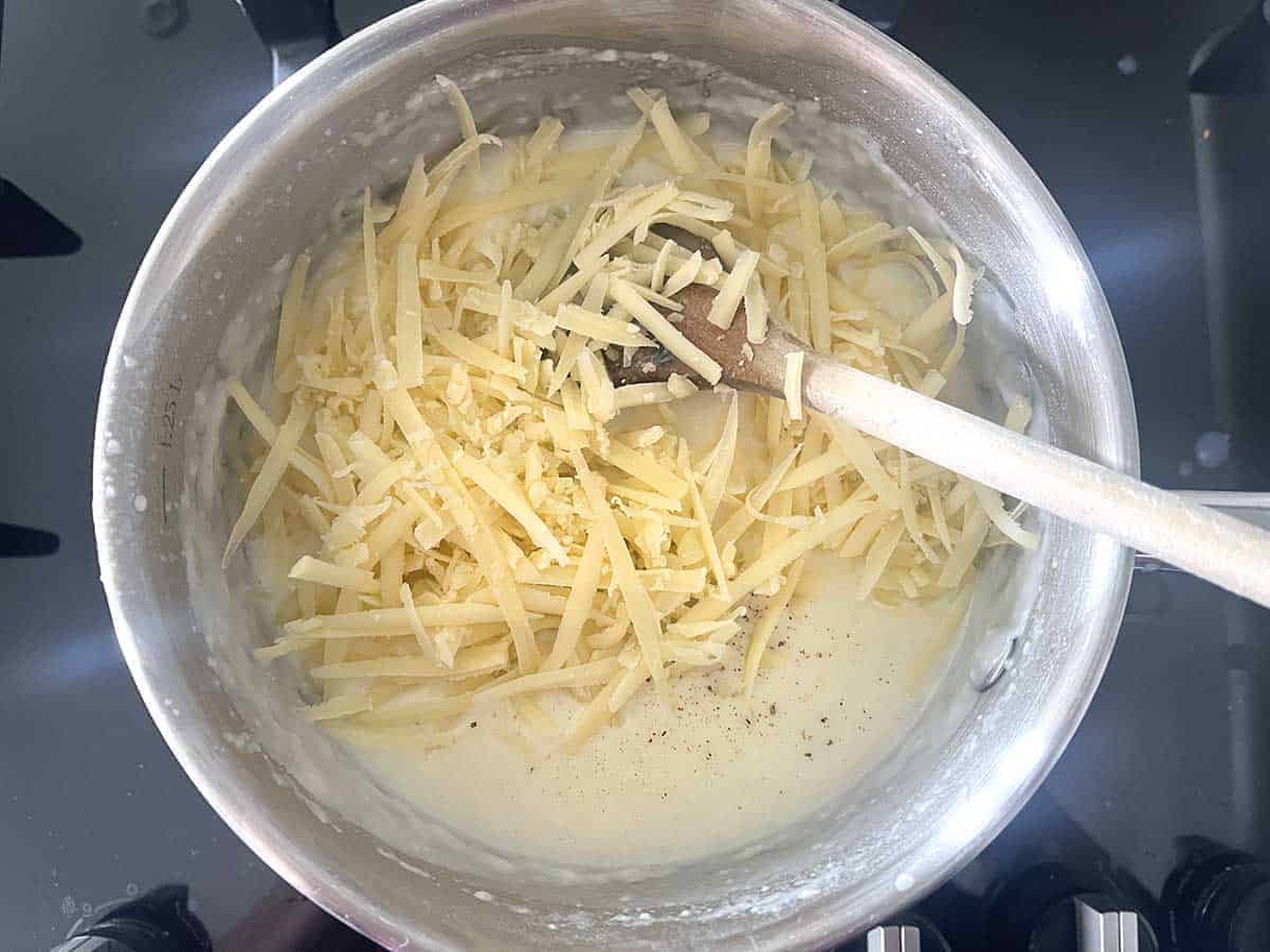 grated cheese added to saucepan.