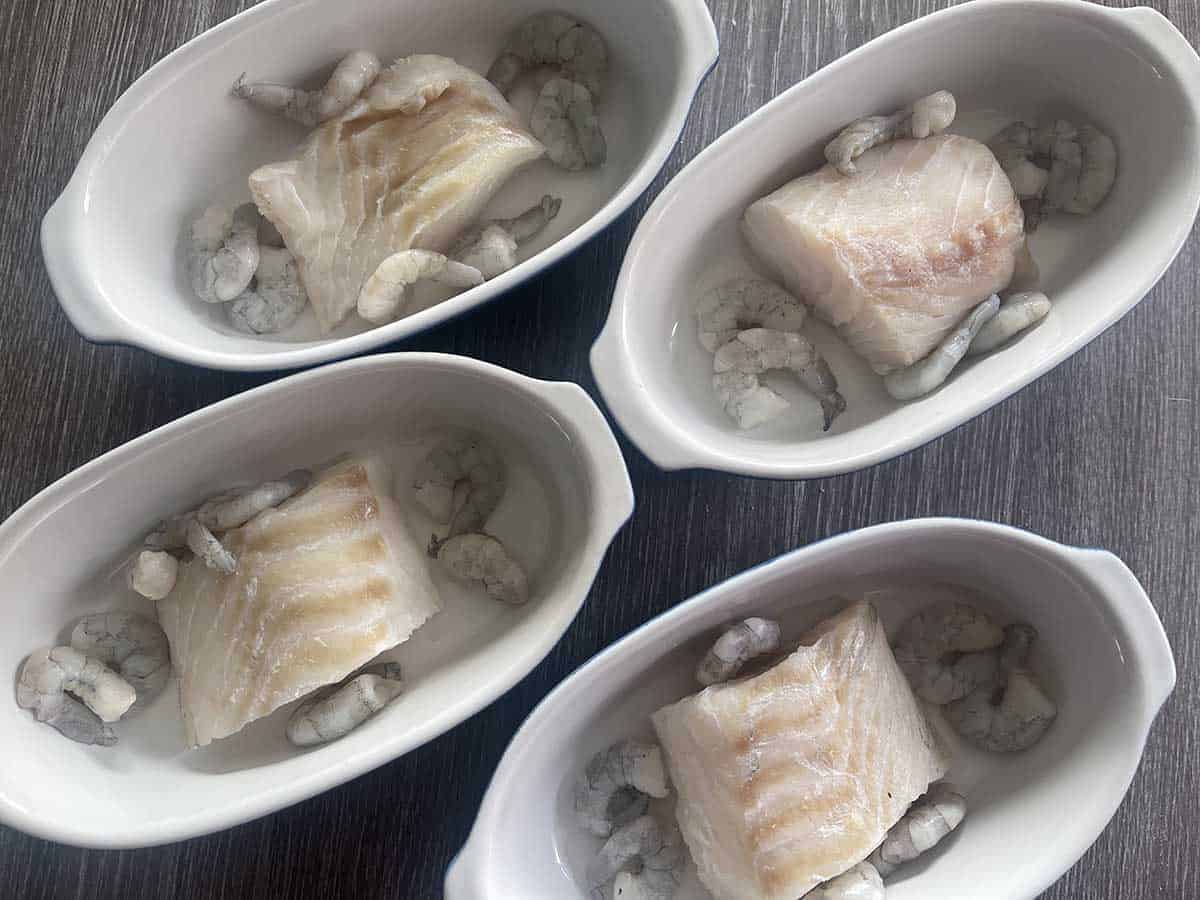 cod and prawns in individual dishes.