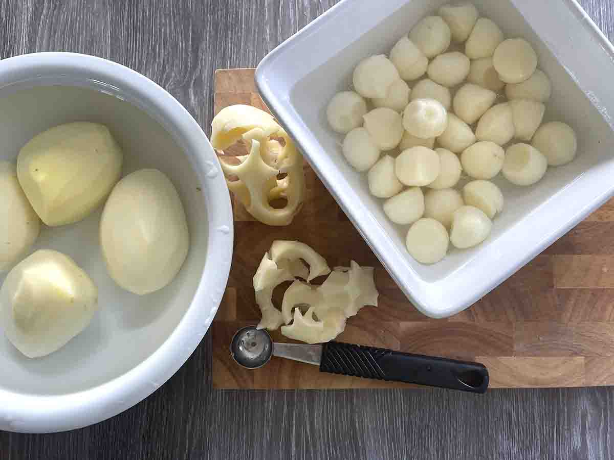 bowl of peeled potatoes and bowl of potato balls.