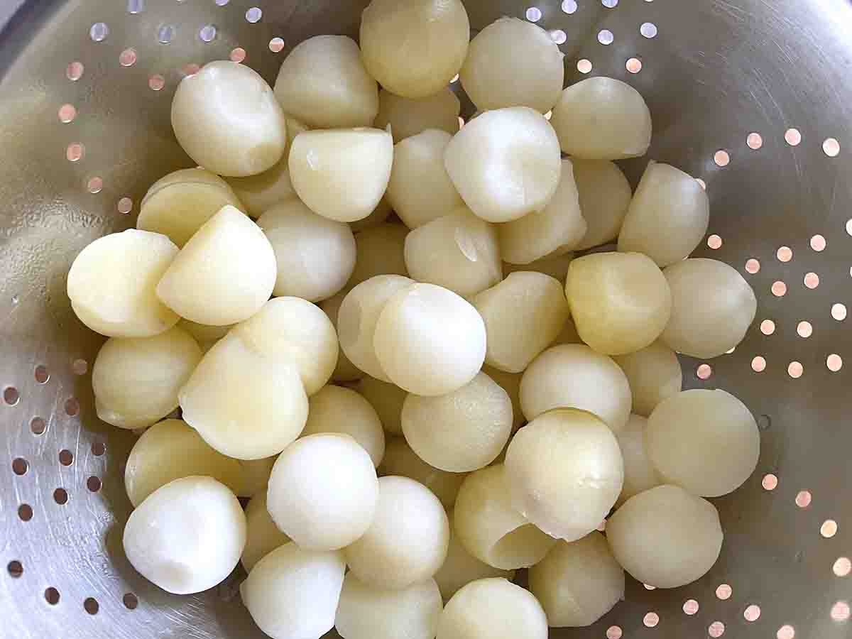 parboiled pommes parisienne in a colander.