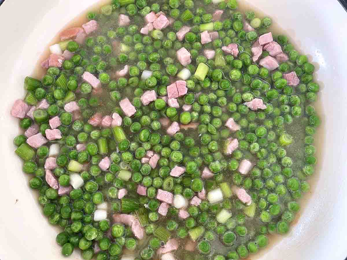 pan with peas, stock and wine added.