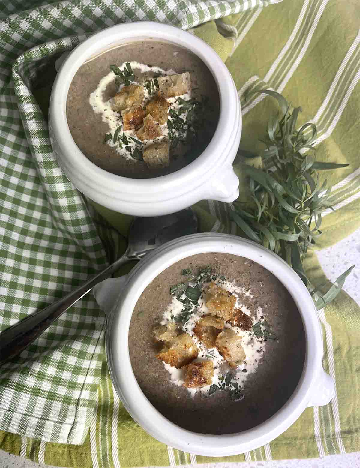 tarragon and mushroom soup in white bowls.