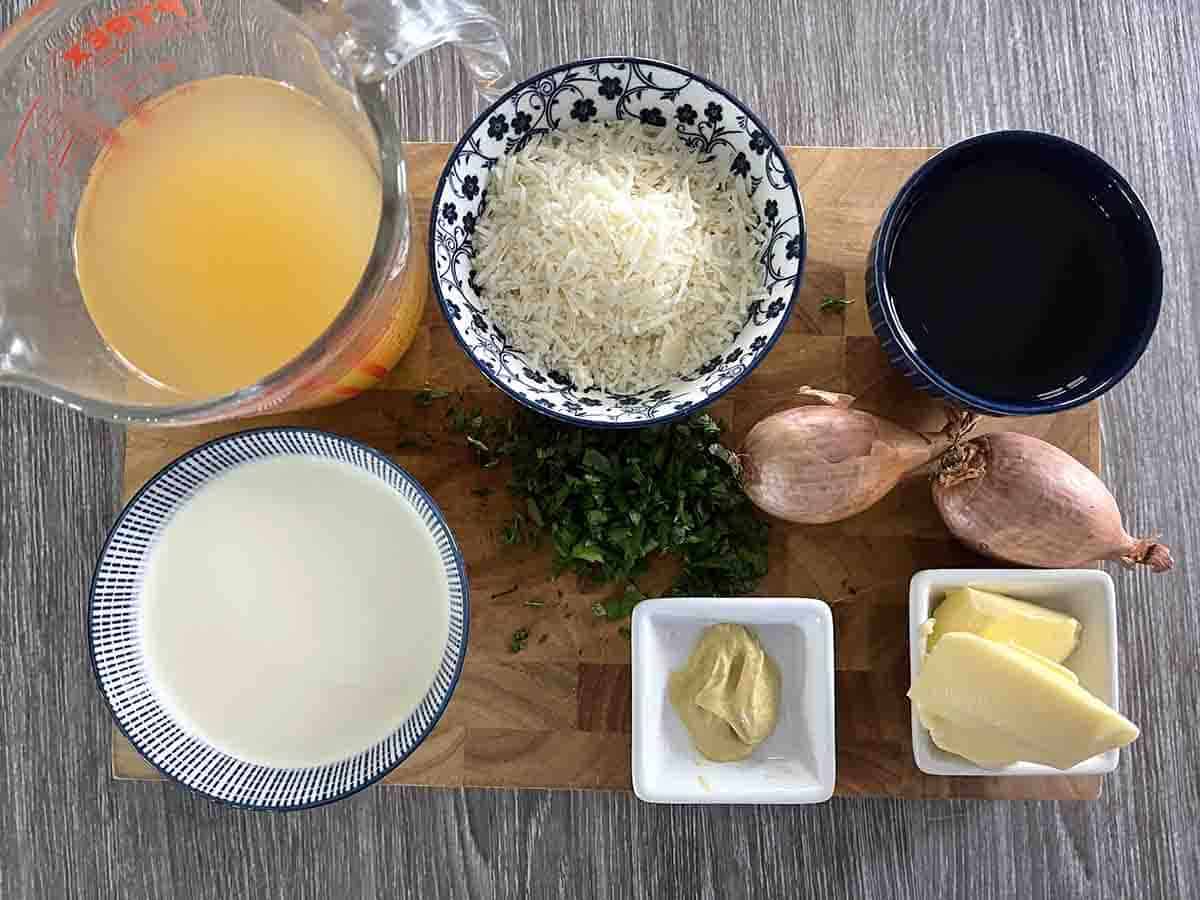 ingredients for thermidor sauce including Parmesan, butter, shallots, stock, wine, cream and parsley.