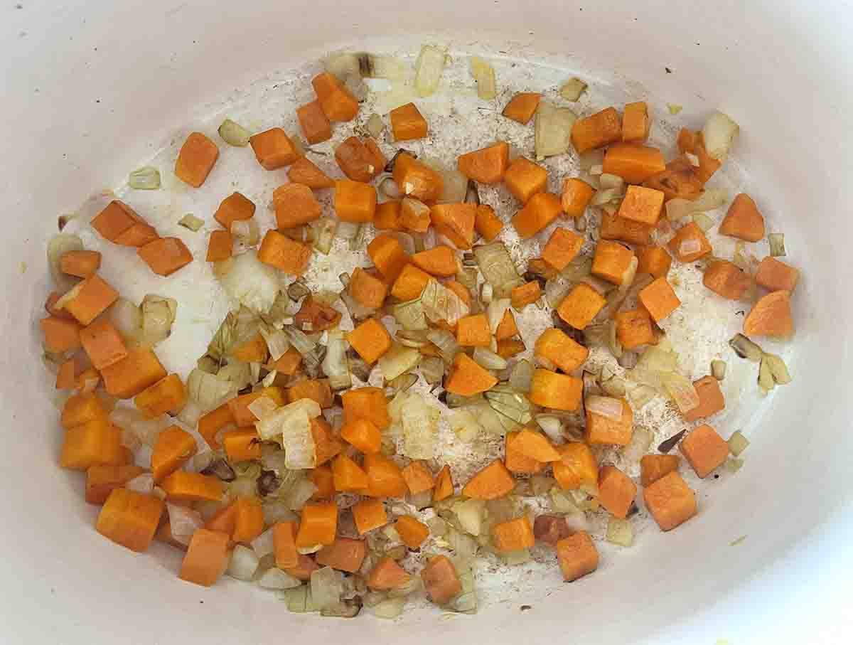 carrots, onions and garlic frying in a pan.