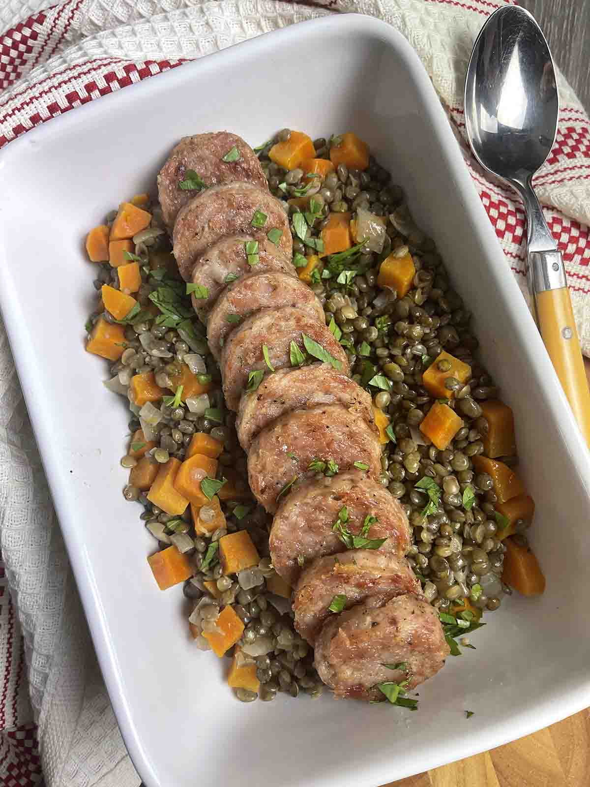cotechino sausage sliced on a bed of green lentils.