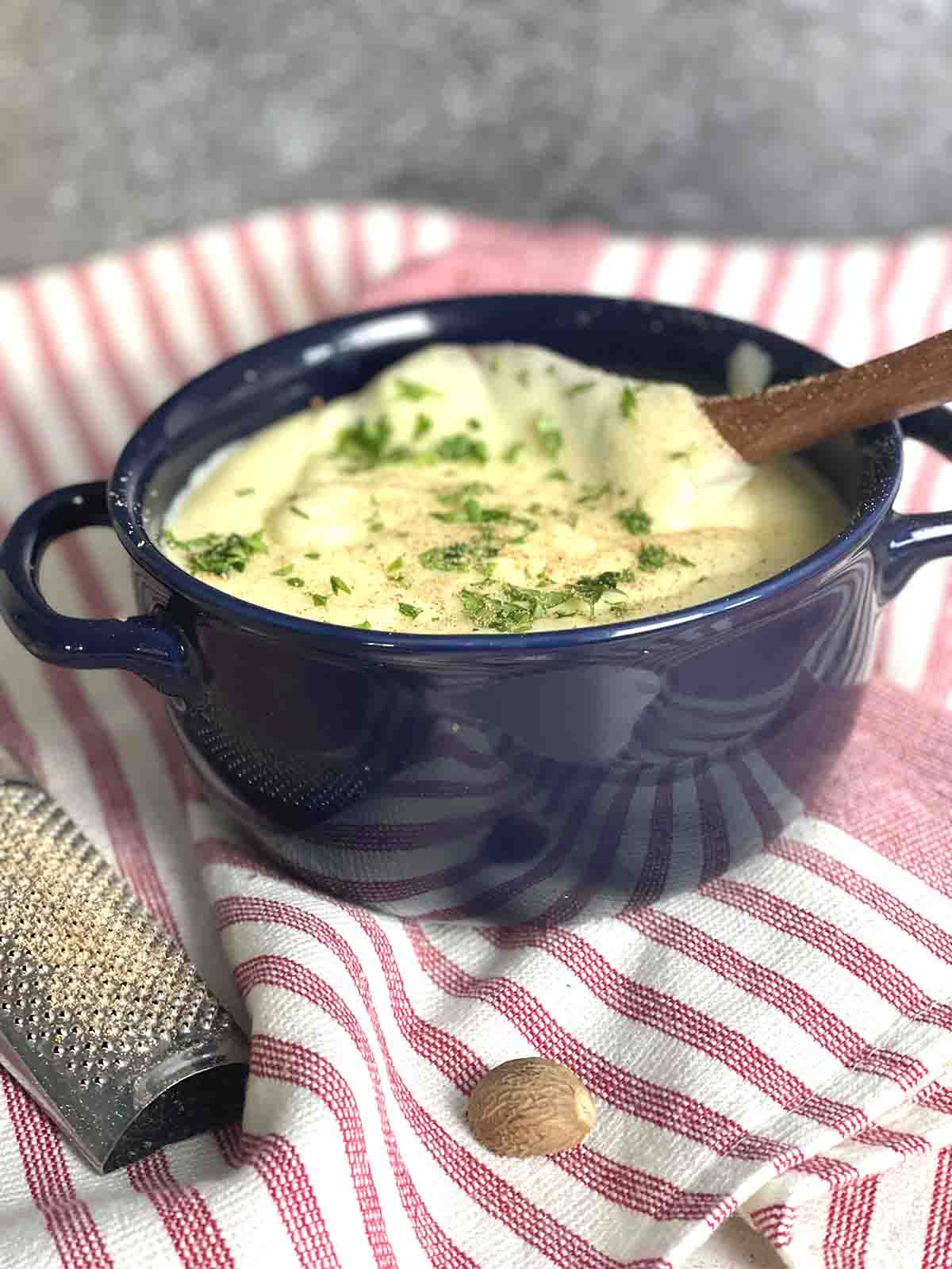 french cheesy mashed potatoes aligot in a bowl with a spoon.