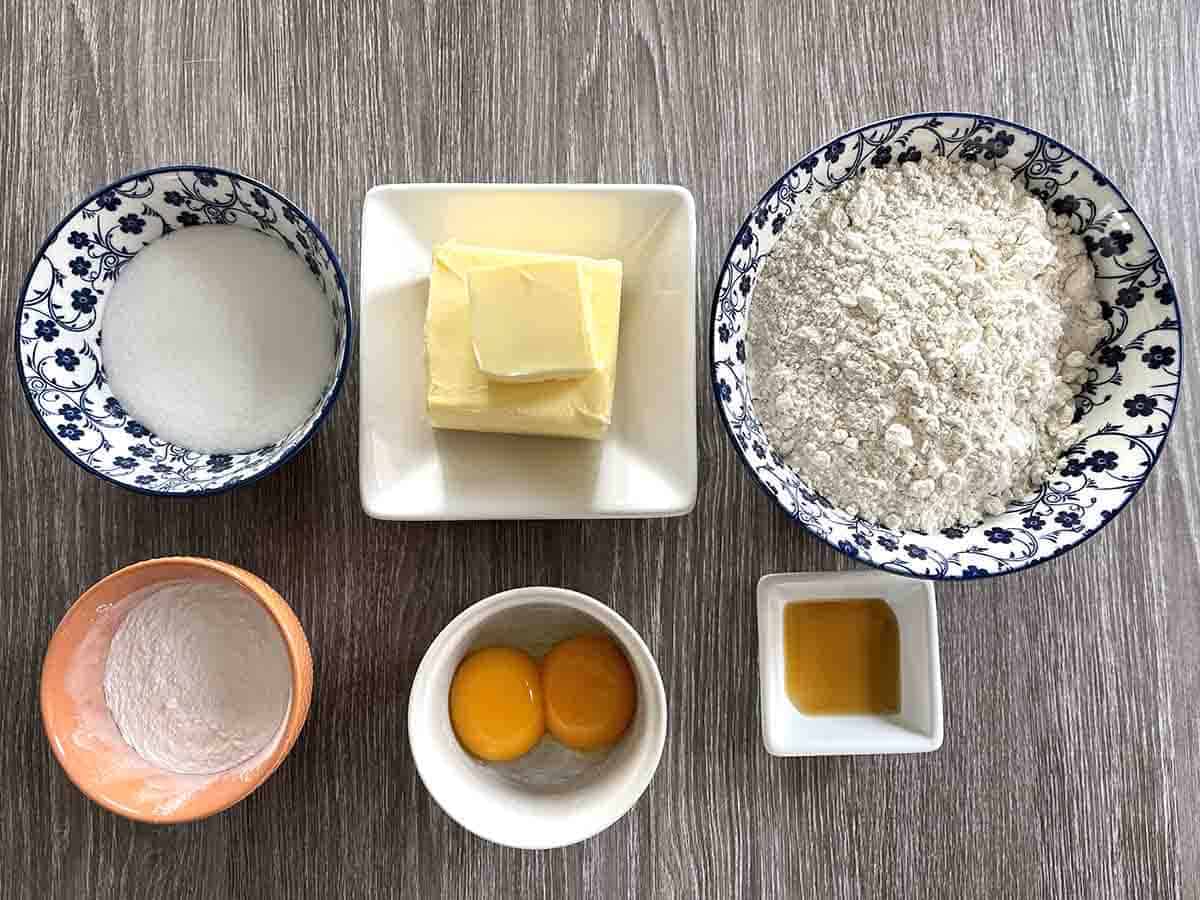 ingredients on dishes imcluding butter, sugar, eggs, flour and vanilla.